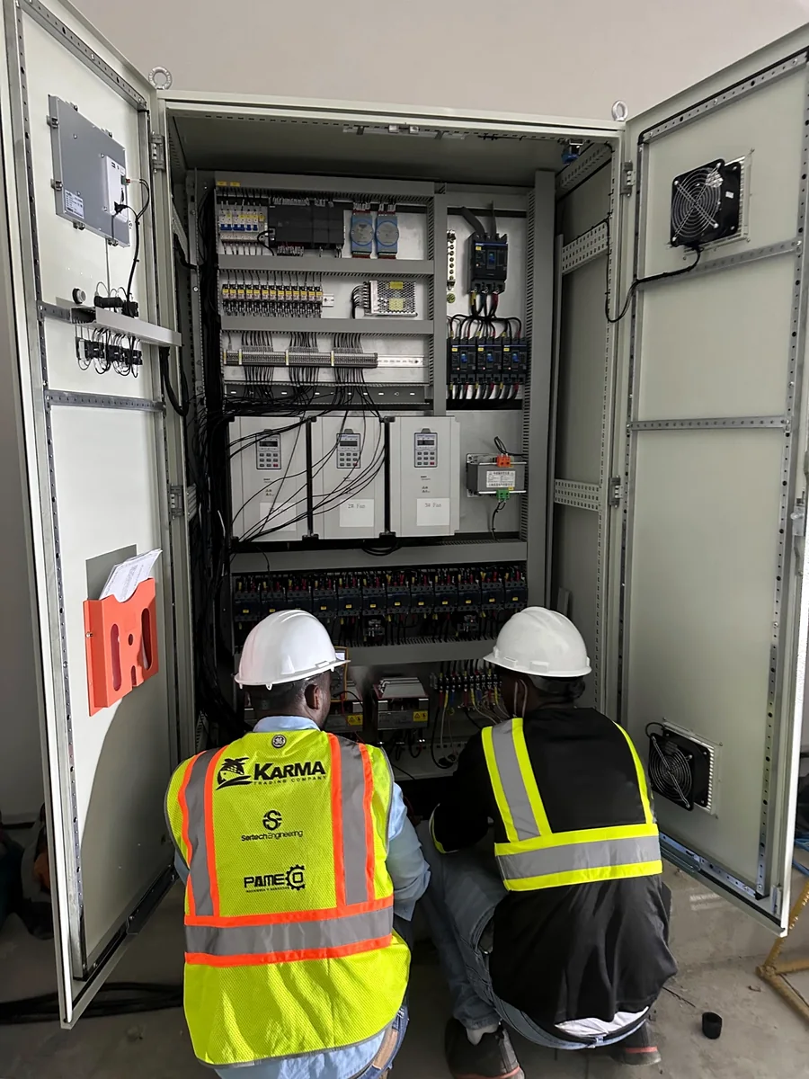 Technical personnel working on the system control panel